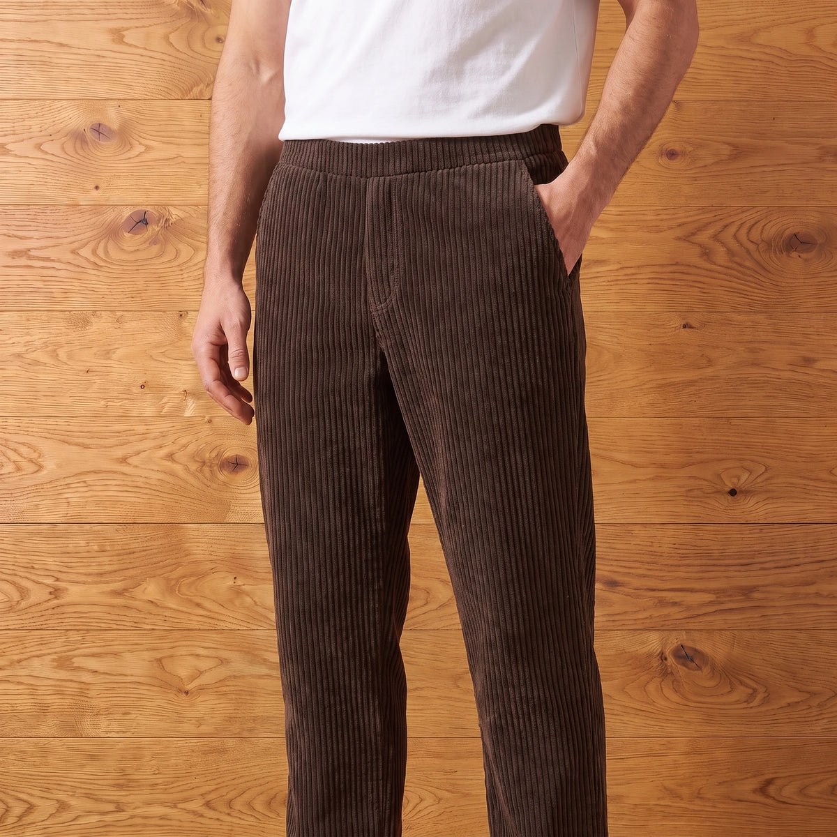 Man wearing brown thick rib corduroy trousers with a white tee
