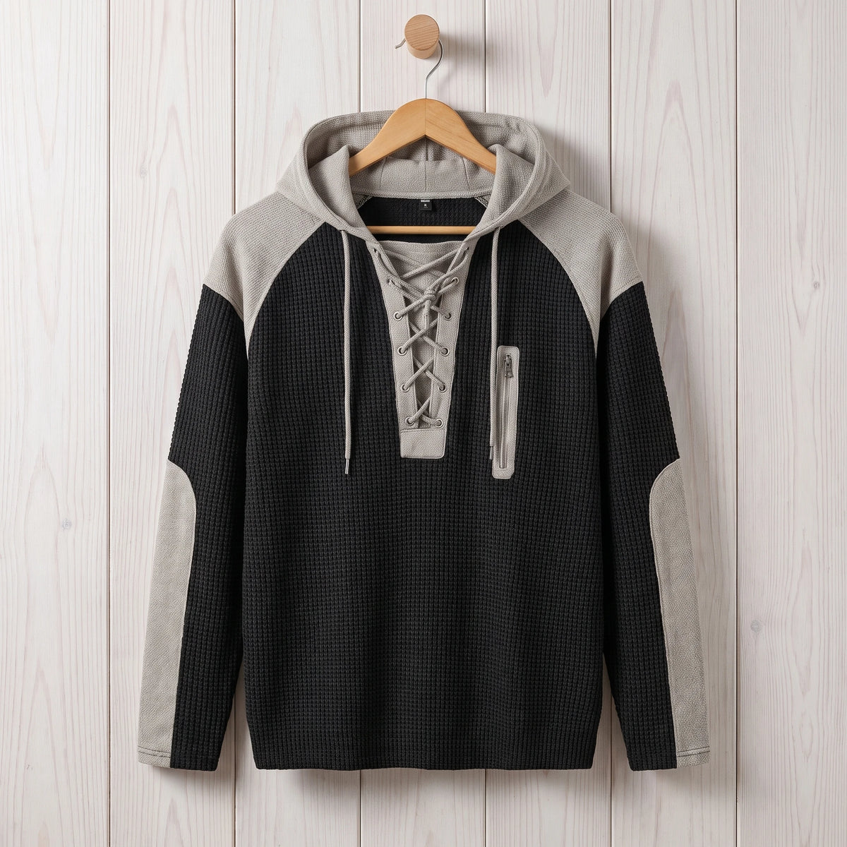 Men's black waffle knit lace-up hooded sweater hanging on a wooden hanger