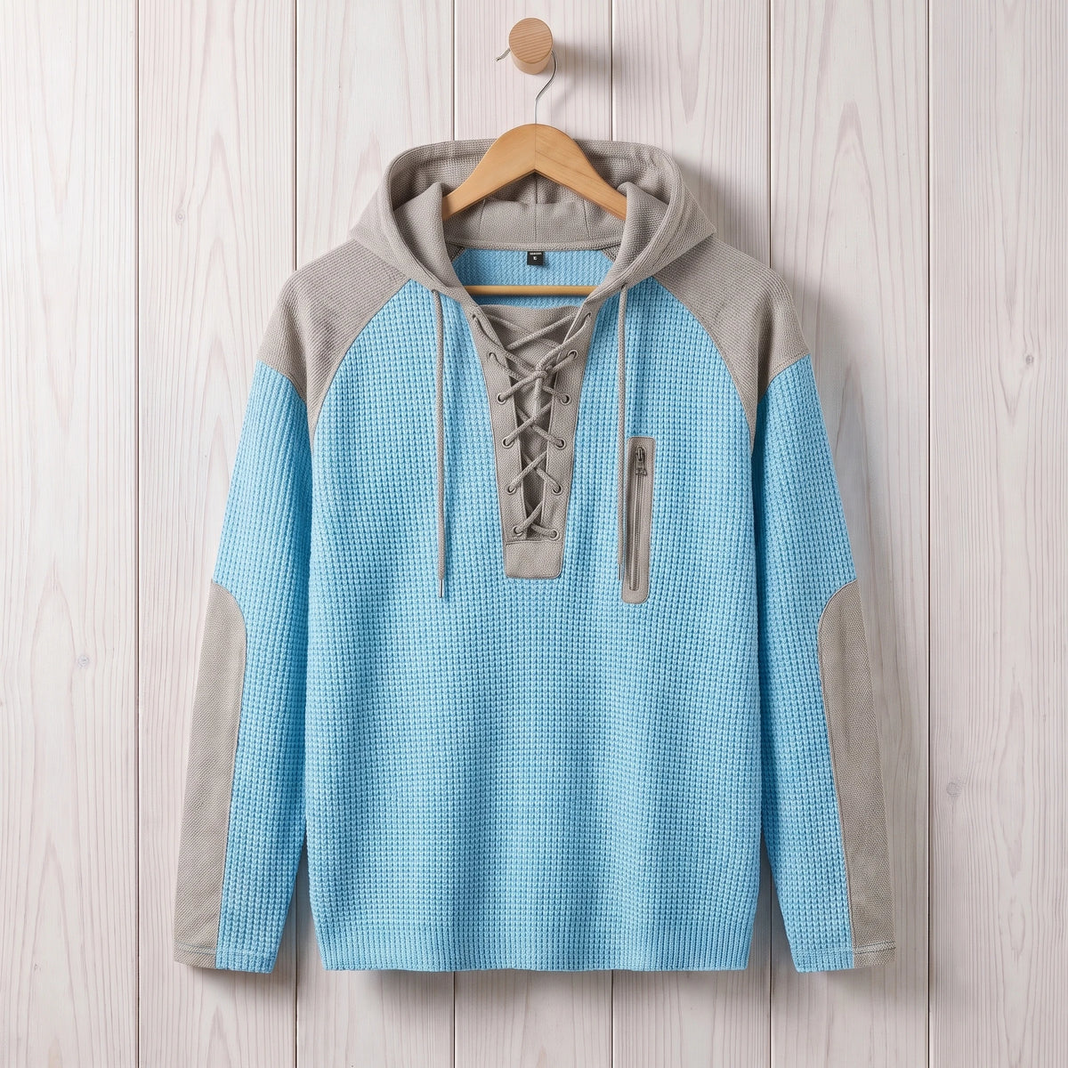 Men's light blue waffle knit lace-up hooded sweater hanging on a wooden hanger
