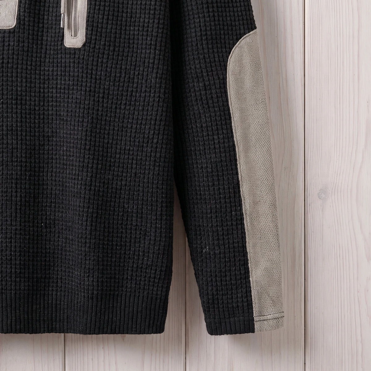 Close-up of the sleeve and elbow patch on the black waffle knit hooded sweater