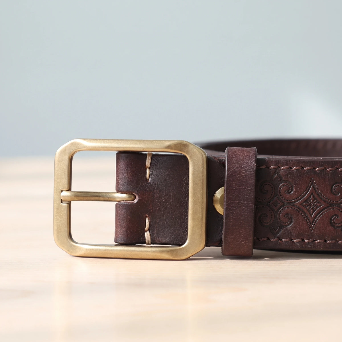 EMBOSSED COWHIDE BELT brass buckle close-up
